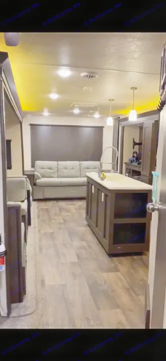 Spacious & modern RV rental interior with living area, kitchen island, and wood flooring for comfortable travel.. Forest River Wildwood 2018