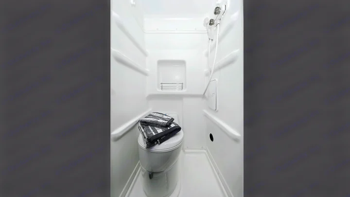 See inside an RV rental's compact wet bath, featuring a toilet, shower, and built-in storage.. Winnebago Winnebago 2021