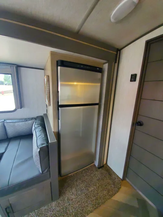 This RV rental's modern interior features a sleek stainless steel refrigerator, control panel, and comfortable grey seating.. Cruiser Rv Corp Cruiser 2021