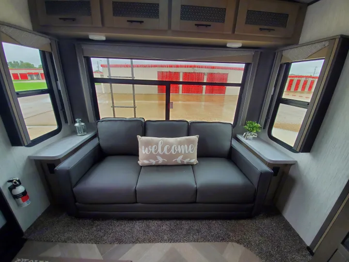 RV rental: Modern RV interior features a comfy sofa with a 'welcome' pillow, side shelves, and windows overlooking storage units.. Cruiser Rv Corp Cruiser 2021