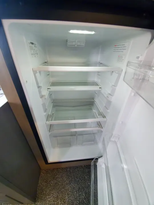Inside a spotless RV rental refrigerator: empty shelves, bright light, and clear bins. Ready for your trip!. Cruiser Rv Corp Cruiser 2021