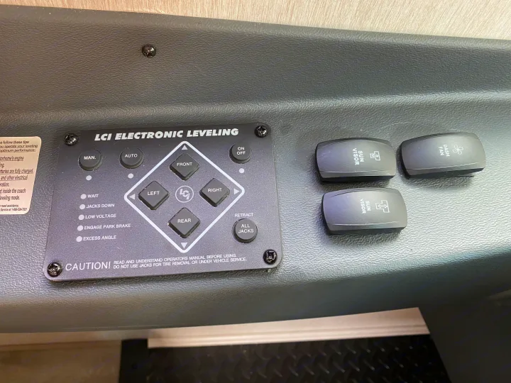 RV rental dashboard: LCI electronic leveling system controls with Sun Visor and Dash Fan switches for comfortable travel.. Coachmen Mirada 2021