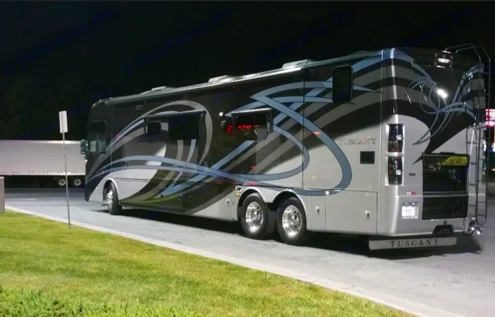 Luxurious Tuscany RV, ideal for an **RV rental** adventure. This sleek motorhome is parked at night, ready for travel.. Thor Motor Coach Tuscany 2016