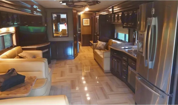Spacious, luxury RV rental interior featuring a full kitchen with stainless appliances, comfortable living area, and modern wood finishes.. Thor Motor Coach Tuscany 2016