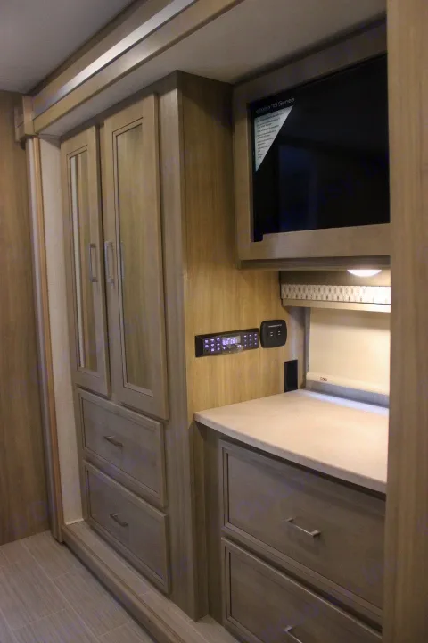 RV rental interior with light wood cabinets, wall-mounted TV, counter space, and integrated media systems.. Other Other 2019