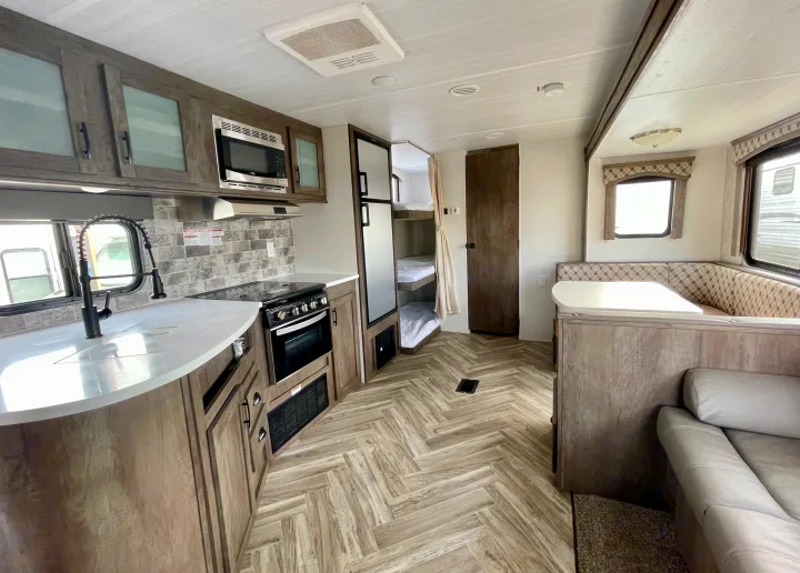 Explore this RV rental's inviting interior: modern kitchen, comfortable dinette, and efficient bunk beds.. Forest River Evo T2550 2019
