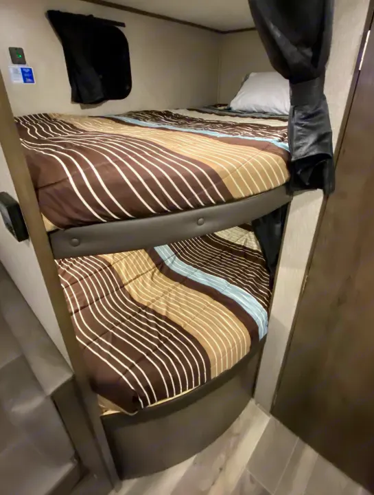 RV rental bunk beds: cozy, striped comforters & privacy curtains for compact sleeping in your camper.. Jayco Jay Flight SLX 2021
