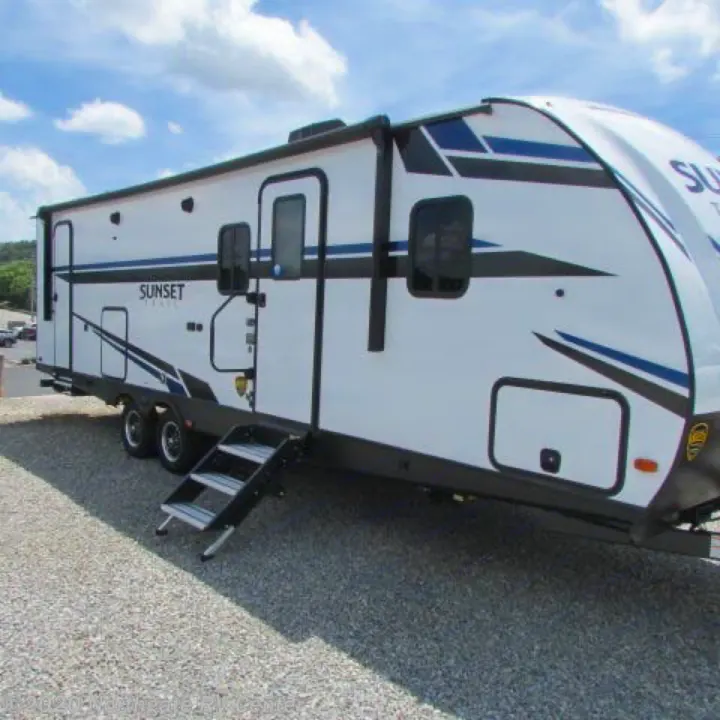 Explore with this sleek white Sunset Trail **RV rental**, featuring blue accents. Parked on gravel, ready for your next outdoor journey.. Other Other 2021