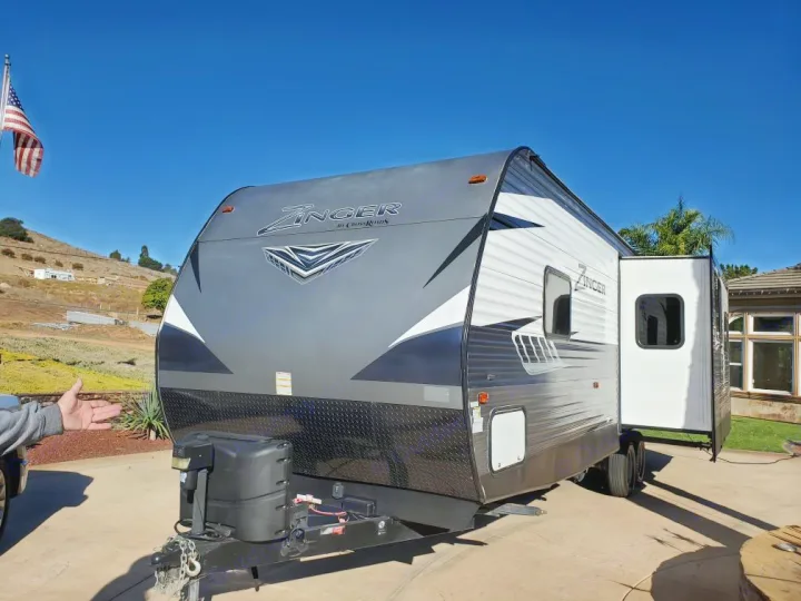 This clean gray and white Zinger travel trailer, with an extended slide-out, is ready for your next RV rental adventure.. Crossroads Zinger 2018