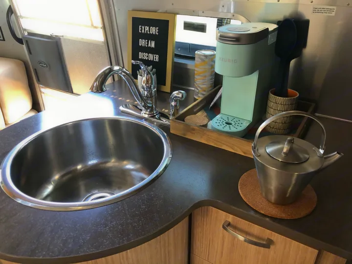 RV rental's compact kitchen: sink, Keurig, and teapot, ready for your next "explore, dream, discover" adventure.. Airstream Flying Cloud 2019