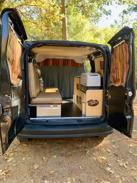 Inside an RV rental camper van conversion: custom interior with bed, fridge, and storage, ready for adventure.. Dodge Ram Promaster City 2016
