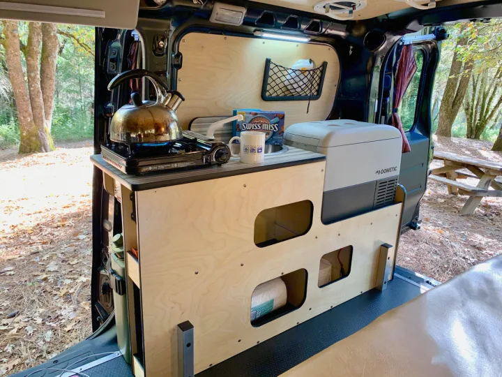 This rv rental features a well-equipped mobile kitchen with a camping stove, kettle, Dometic fridge, and organized storage for adventures.. Dodge Ram Promaster City 2016