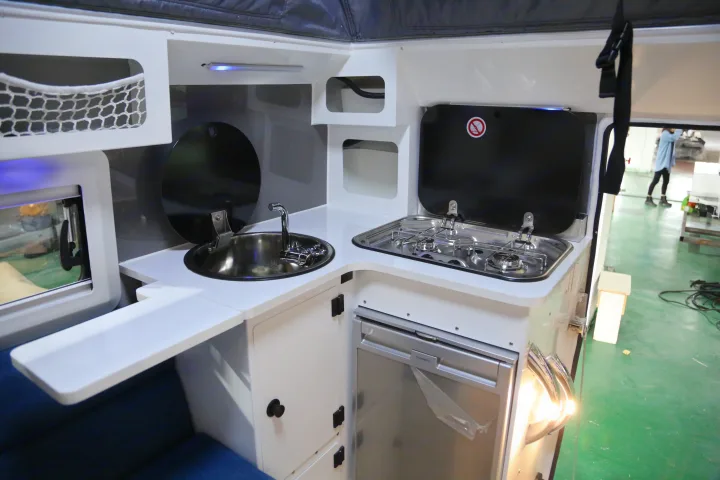 This rv rental showcases a compact, modern kitchen with sink, two-burner stove, fridge, and built-in storage.. Other Other 2021