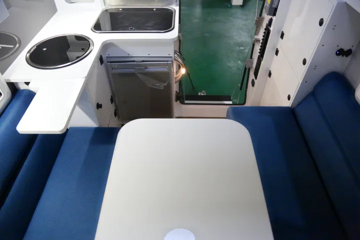 Explore this RV rental's cozy interior: a compact kitchenette, Dometic fridge, and comfy blue dining area with a table.. Other Other 2021