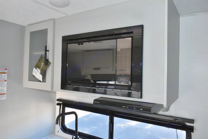 Modern RV rental kitchen interior featuring a built-in microwave, overhead cabinets, and range hood.. Forest River Salem 2021