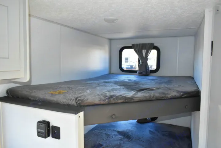 Inside an RV rental: cozy bunk beds with a window, ideal for camper travel accommodation.. Forest River Salem 2021