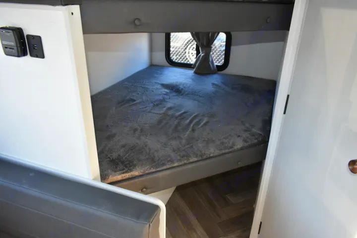 RV rental bunk bed area: features a lower bunk with grey bedding, a window, wall controls, and herringbone flooring.. Forest River Salem 2021