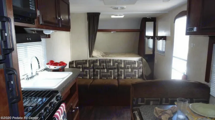 This RV rental interior features a functional kitchen, dinette, and comfortable bunk beds, offering a complete living space.. Eclipse Recreational Vehicles Milan 2013