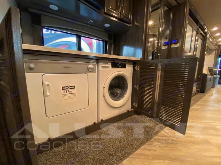 Stacked washer/dryer unit in an RV rental, with open louvered doors showcasing modern laundry amenities.. Fleetwood Pace Arrow 2021