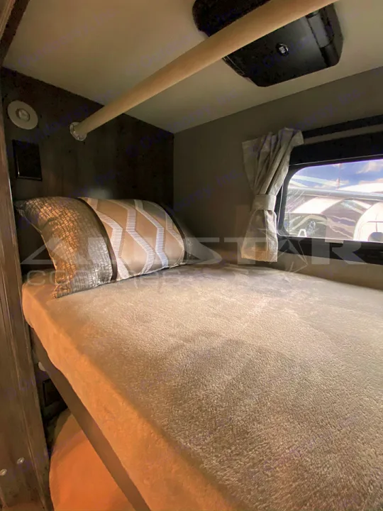 RV rental's bunk bed area features soft bedding, window, and overhead safety bar for a cozy stay.. Fleetwood Pace Arrow 2021