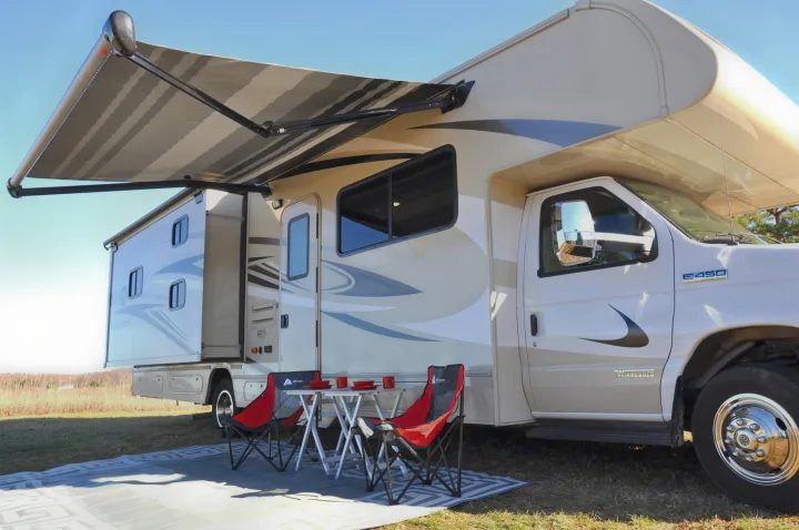 Winnebago E450 rv rental with extended awning, slide-out, and outdoor seating setup on a clear day.. Winnebago Minnie Winnie 2020