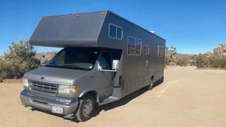 Explore the desert! This gray Ford E-350 RV rental is ready for adventure amidst Joshua trees and rocky landscapes.. Jayco Greyhawk 2002