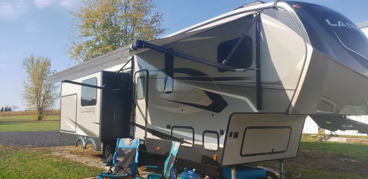 RV rental setup: This Laredo fifth wheel is ready for outdoor living with extended awnings and chairs.. Keystone RV Laredo 2020