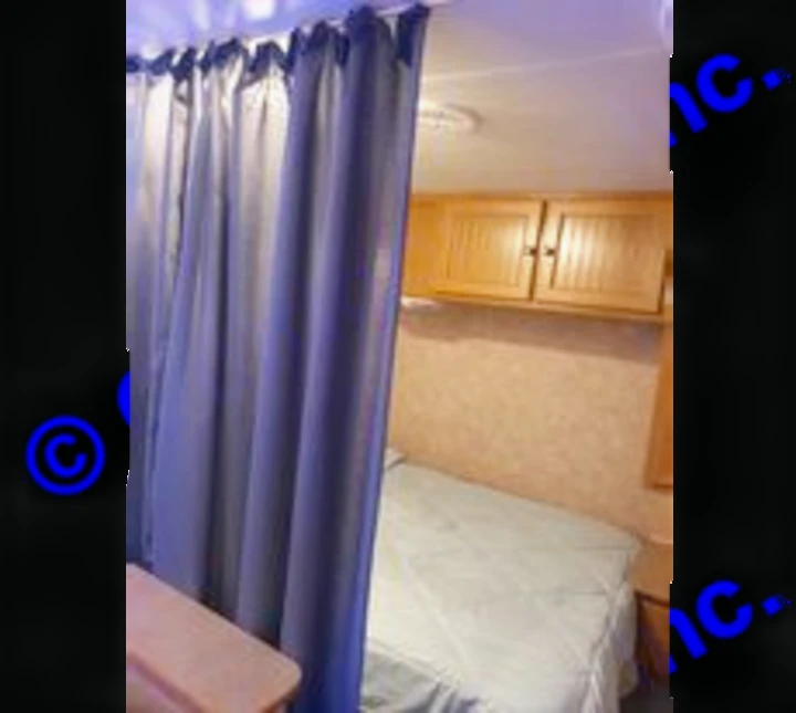 Privacy curtain pulled for full size bedroom. Dutchmen Sport 2004