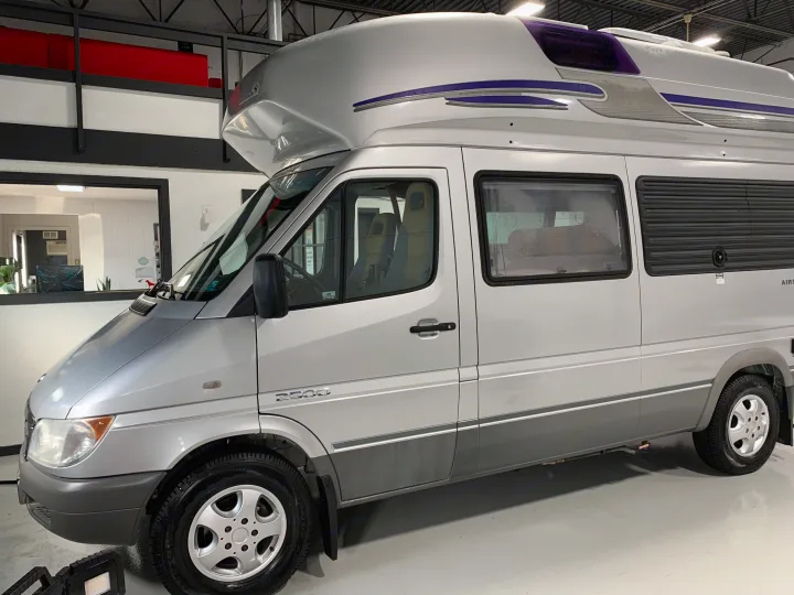 Silver Mercedes-Benz Sprinter Airstream Westfalia RV conversion, showcased indoors. A spacious and versatile rv rental choice.. Airstream Westfalia 2005