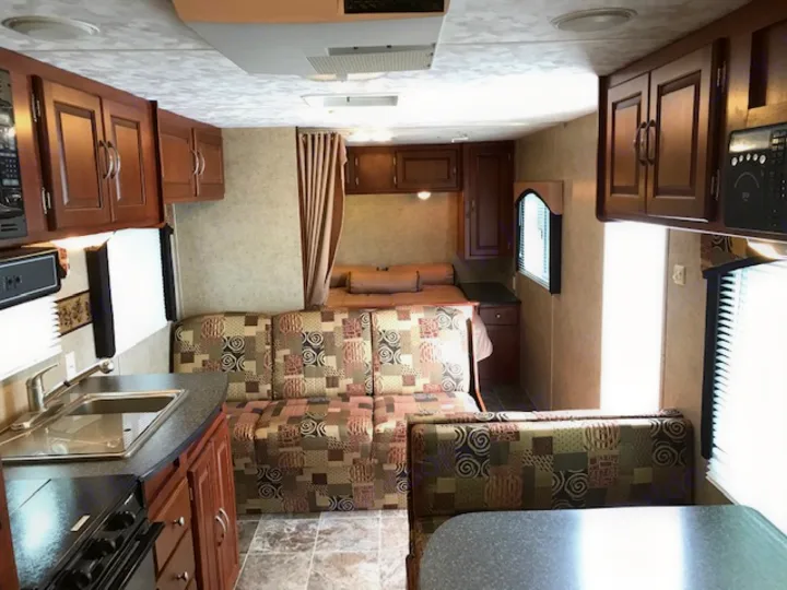 Spacious RV rental interior featuring a full kitchen, sofa, dinette, and bed area for comfortable travel.. Wildwood Wildwood 2011