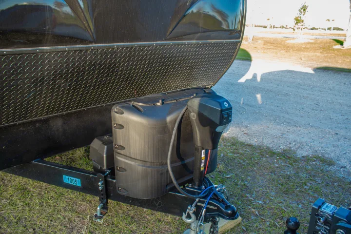Front hitch area of an RV rental, featuring propane tanks, electric jack, and diamond plate rock guard. Ready for travel.. Heartland M-33 2021
