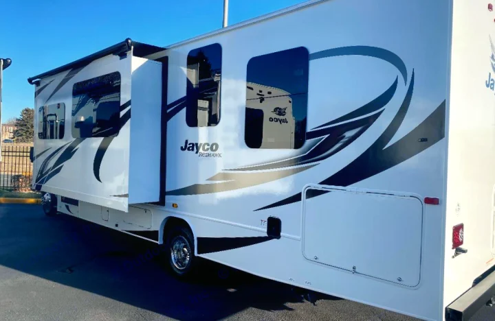 Side view of a white Jayco Redhawk RV rental with an extended slide-out, perfect for your next road trip adventure.. Jayco Redhawk 2021
