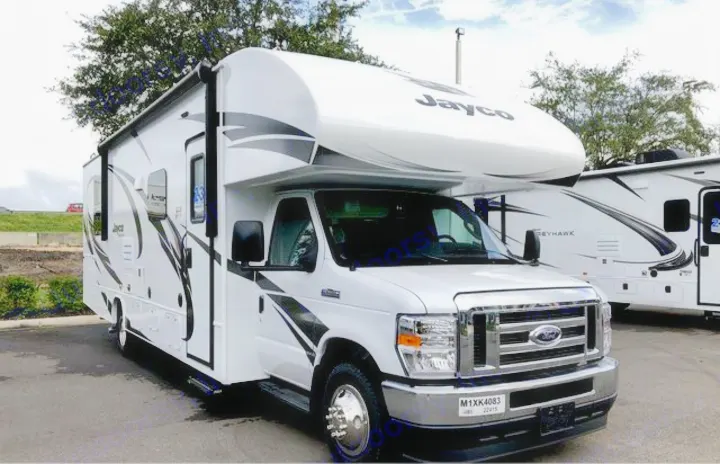 New white Jayco Class C RV motorhome, perfect for an rv rental! Features modern black graphics, parked outdoors.. Jayco Redhawk 2021