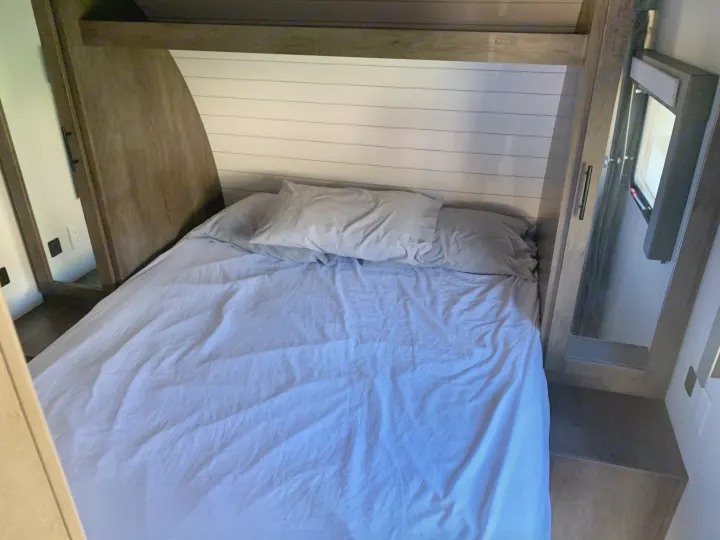 Cozy RV rental bedroom with a comfy bed, modern headboard, and window.. Forest River Salem Cruise Lite 2020