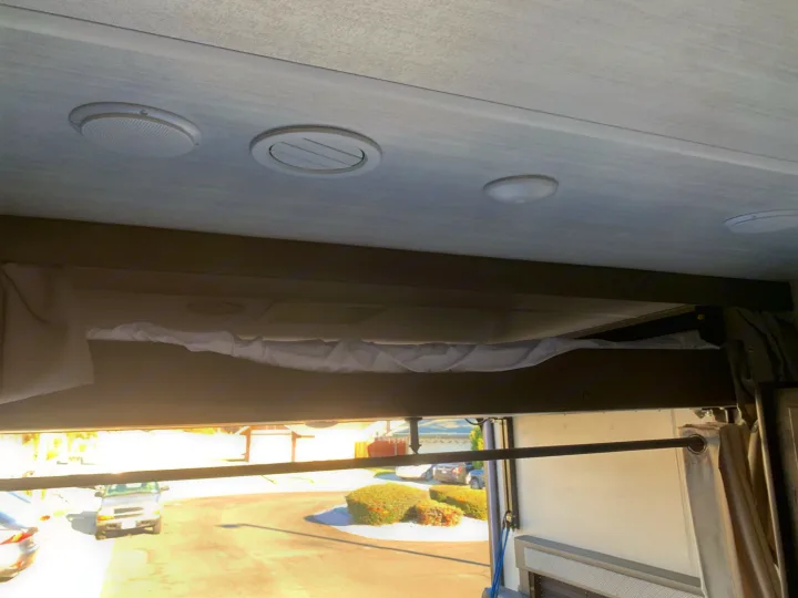 Inside an RV rental: ceiling with speakers, vents, and lights, plus a bunk bed. Bright outdoor view.. Forest River Salem Cruise Lite 2020