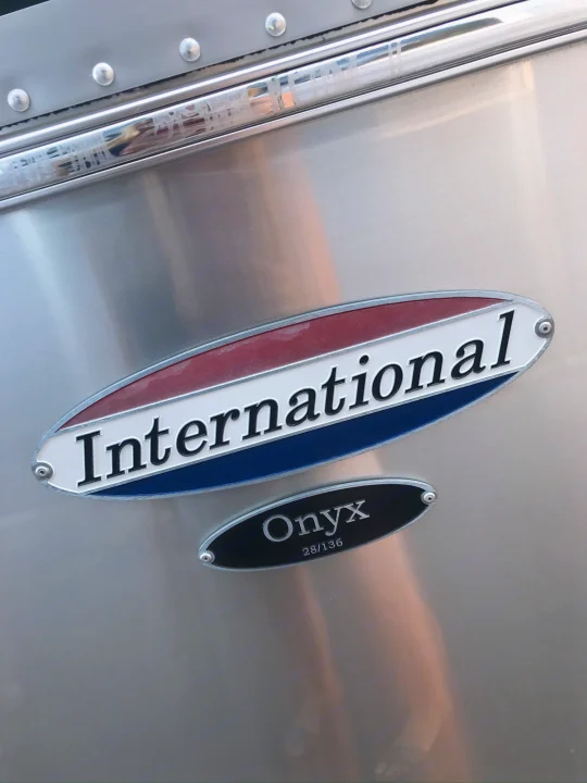 International Onyx 28/136 RV rental's polished aluminum side with its distinctive badges.. Airstream International 2014