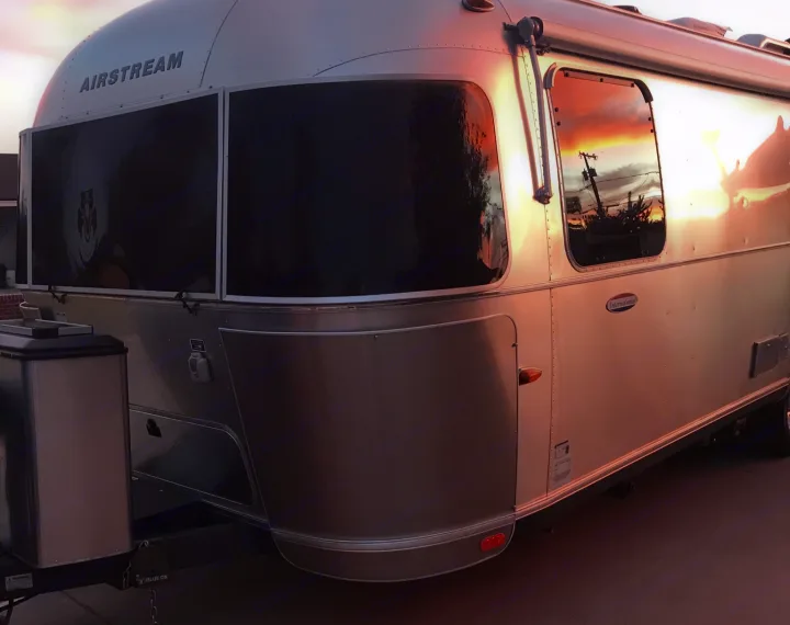 This Airstream rv rental glows silver, reflecting a vibrant sunset.. Airstream International 2014