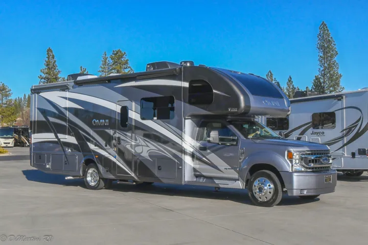 A modern grey Super C RV rental, a Thor Omni motorhome, parked outdoors on asphalt for travel adventures.. Thor Motor Coach Other 2021