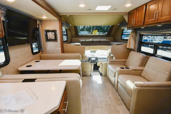 Explore this RV rental's inviting interior: dining booth, comfortable lounge seating, and TV.. Thor Motor Coach Other 2021