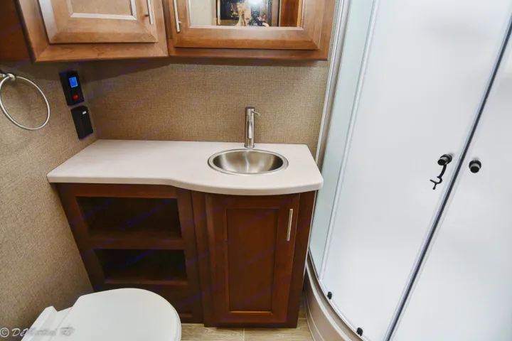 RV rental: Well-appointed bathroom features a wood vanity, stainless sink, and curved shower enclosure for travel.. Thor Motor Coach Other 2021