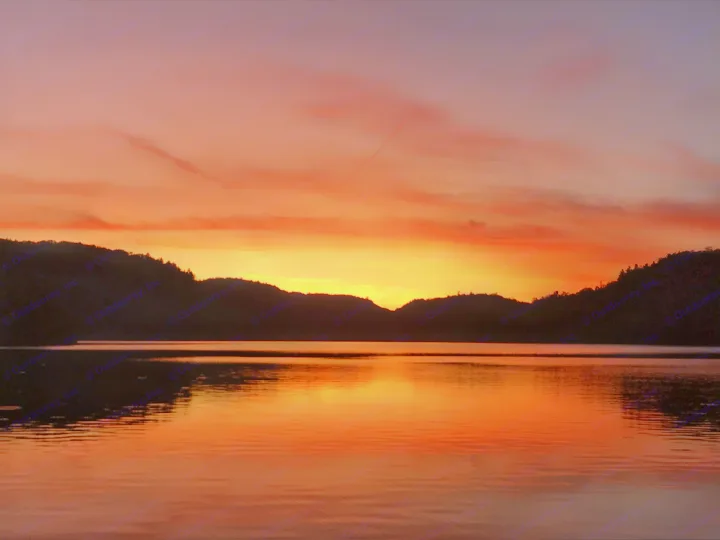 Stunning orange and red sunset reflected on a calm lake, silhouetted hills. Ideal for your next RV rental adventure.. Jayco Other 2004