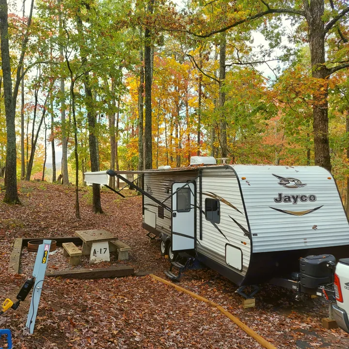 Beautiful fall rv rental campsite with a Jayco travel trailer, vibrant trees, picnic table, and fire pit.. Jayco Jay Flight SLX 2018