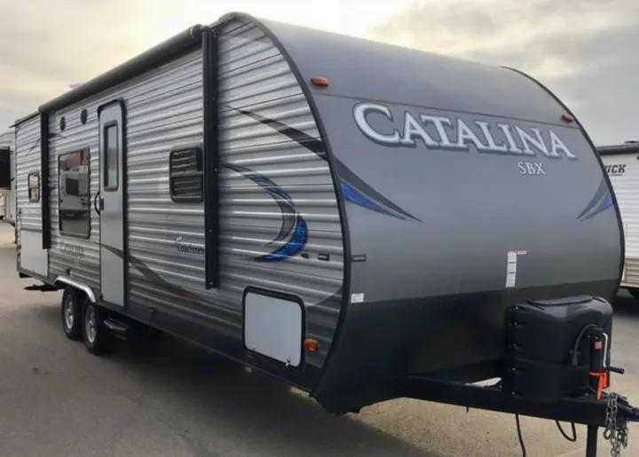 A grey Catalina SBX travel trailer with a large awning, perfect for an rv rental adventure.. Coachmen Catalina 261 2019