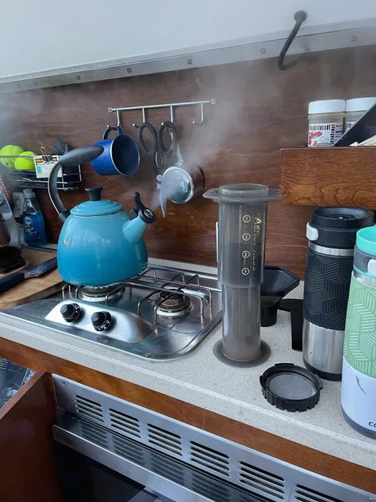 Steaming kettle & AeroPress make coffee in an RV rental kitchen. Compact setup with mugs, ideal for on-the-go travel.. Nucamp T@G MAX 2018