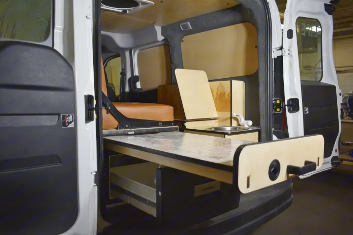 This RV rental shows a clever van conversion interior: a pull-out table, sink, ample storage with a Dometic unit, and seating.. Dodge Promaster City 2020