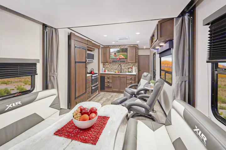 Comfortable RV rental interior featuring a full kitchen, dining area, recliners, and scenic window views. Perfect for travel.. Forest River XLR HYPERLITE 2815 2021