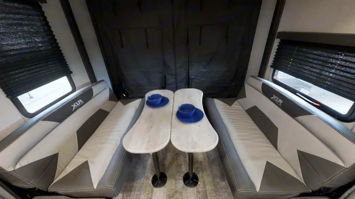 Spacious RV rental dinette featuring two comfortable benches, dual tables, and large windows with blinds.. Forest River XLR HYPERLITE 2815 2021