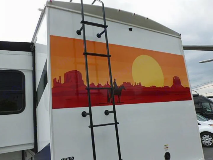 Rear of an RV rental: features a vibrant desert sunset graphic with a cowboy silhouette & a mounted ladder.. Forest River Sunseeker 2020