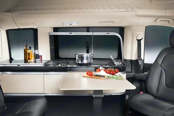 RV rental interior: a compact mobile kitchen with stove, sink, and prep table, ready for your next adventure.. Mercedes Marco Polo Class V 250d 2022