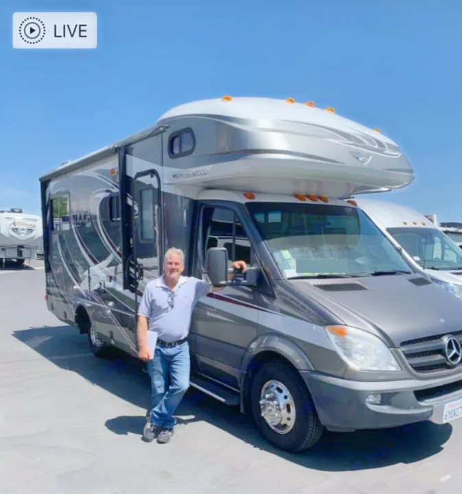 Happy man with his grey Mercedes-Benz RV rental. Ready for road trips and adventure.. Fleetwood Tioga 2011